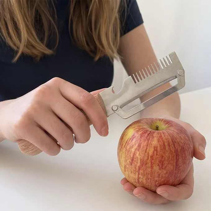 A woman peels a red apple with PeelPro
